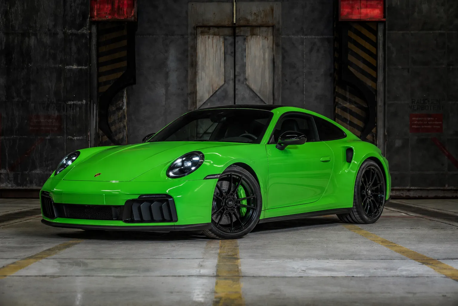 Grüner Porsche 911 vor dem ursprünglichen industriellen Hintergrund